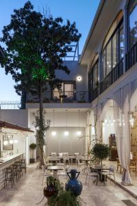 a patio with tables and chairs and a tree at Delight Deluxe Hotel in Antalya