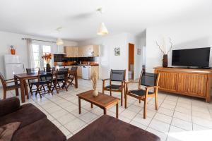 a living room with a couch and chairs and a kitchen at Paradiles in Dolus d'Oléron