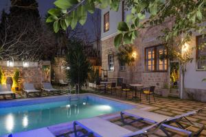 a pool with chairs and tables next to a building at Delight Deluxe Hotel in Antalya