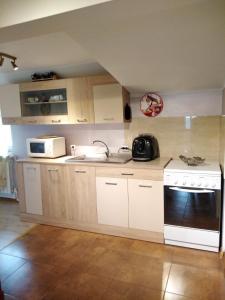uma cozinha com armários brancos e um forno preto em Casa Mamei em Suceava