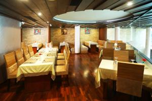een restaurant met tafels en stoelen en een bakstenen muur bij Hotel Kabani Regency in Ernakulam