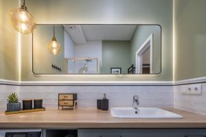 a bathroom with a sink and a large mirror at LIVING & LIFESTYLE home - Klaipeda - by Hello Sea homes in Klaipėda