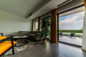 una sala de estar con un sofá y una mesa en Villa Piante - Pool, Whirlpool, en Antonci