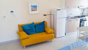 ein gelbes Sofa mit zwei blauen Kissen in der Küche in der Unterkunft Casa Vacanze Kiara in Terrasini