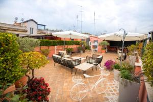 a patio with a bike and tables and umbrellas at Restart Accommodations Rome in Rome