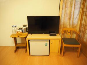 a tv on top of a desk with a small refrigerator at Shexia Liyu Hot Spring in Checheng