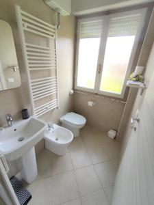 bagno con lavandino, servizi igienici e finestra di La Mimosa Chic a Pietrasanta