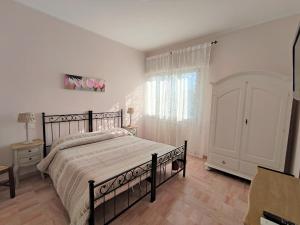 ein Schlafzimmer mit einem großen Bett und einem Fenster in der Unterkunft La Mimosa Chic in Pietrasanta