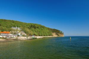 a body of water with a beach and a mountain at Pirate Apartment - Seaside in Gdynia
