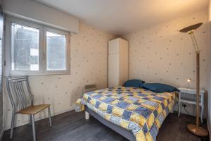 een slaapkamer met een bed, een bureau en een raam bij Le Pavois - appartement à 50 mètres de la mer in Bernières-sur-Mer