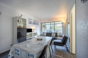 a kitchen and living room with a table and chairs at Le Pavois - appartement à 50 mètres de la mer in Bernières-sur-Mer