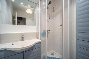 a bathroom with a sink and a shower at Le Pavois - appartement à 50 mètres de la mer in Bernières-sur-Mer +4 photos