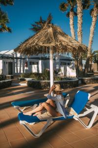プエルト・デル・カルメンにあるMar Azul Playaの傘下の浜椅子に座る女性