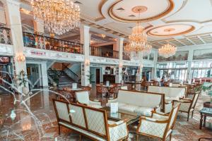 een lobby met kroonluchters en tafels en stoelen bij GRINN HOTEL & SPA in Oryol