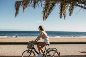 プエルト・デル・カルメンにあるMar Azul Playaの海岸自転車に乗る女