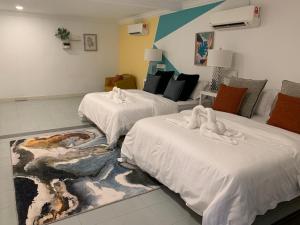 a room with two beds with towel animals on them at MyBed Homestay in Padang Besar