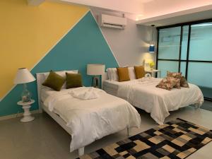 two beds in a room with a blue wall at MyBed Homestay in Padang Besar