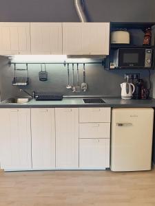 La cuisine est équipée de placards blancs et d'un réfrigérateur blanc. dans l'établissement Apartment 31 Vila Golf Nice Vacation, à Rogaška Slatina