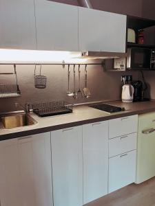 a kitchen with white cabinets and a sink at Apartment 31 Vila Golf Nice Vacation in Rogaška Slatina
