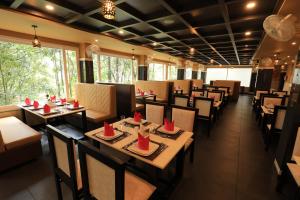 a restaurant with tables and chairs with red napkins on them at AMUSE VISTA RESORTS AND SPA in Anachal