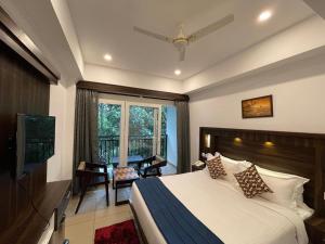 a bedroom with a large bed and a balcony at AMUSE VISTA RESORTS AND SPA in Anachal