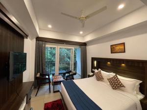 a bedroom with a bed and a table and a window at AMUSE VISTA RESORTS AND SPA in Anachal