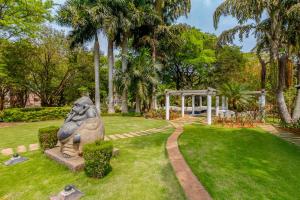 a statue of an elephant sitting in the grass at StayVista at Ananta in Bangalore