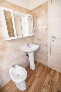 a bathroom with a sink and a toilet at Valery Apartments Alghero in Alghero +22 photos