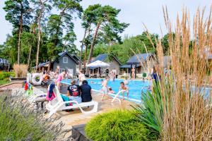 um grupo de pessoas brincando em uma piscina em OŚRODEK KOLONIJNO WCZASOWY MEWA - przy plaży z basenem z podgrzewaną wodą i mini SPA em Niechorze