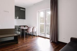 a living room with a kitchen and a table and chairs at FOREST PALANGA RESORT in Palanga