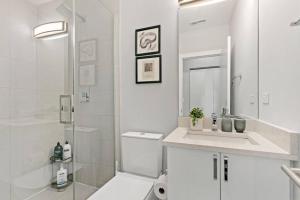 une salle de bain blanche avec une douche et un lavabo dans l'établissement Cozy & Modern 3BR Apartment - Division 201W 301W REP, à Chicago 10 autres photos