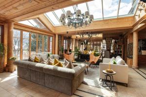a conservatory with a large couch in a room with windows at Hotel Gassner - 4 Sterne Superior - 1200 qm SPA in Neukirchen am Großvenediger