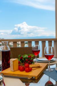 una mesa con dos copas de vino tinto y queso en Apartment Angela, en Trogir