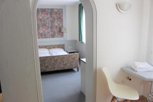 a room with a bed and a desk and a chair at Hotel Ulmer Spatz in Ulm