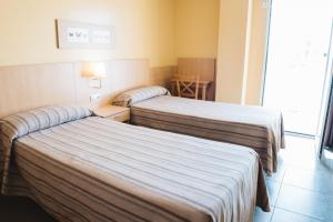 a hotel room with two beds and a window at Apartamentos Turisticos Terralta in Benidorm