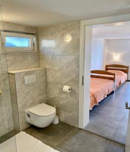 ein Bad mit WC und ein Bett in einem Zimmer in der Unterkunft Holiday Home Oliva in Bol + 23 Fotos