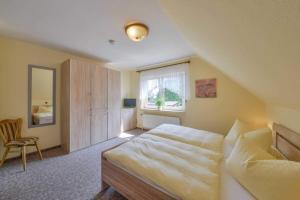 ein Schlafzimmer mit einem großen Bett und einem Fenster in der Unterkunft Landhaus Braband in Cuxhaven