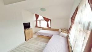 a small bedroom with a bed and a television at Къща за гости Орфей in Smolyan +20 photos