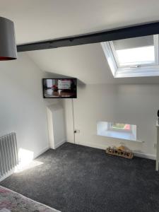 um quarto vazio com uma televisão de ecrã plano na parede em The Nags Head - Room only accommodation em Lyme Regis