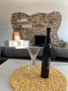 a bottle of wine and a glass on a table at Holiday House Santa in Lopar