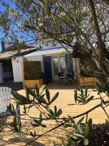 una terraza de madera con sillas y un árbol en Les Bains Boyardville - Hôtel et Restaurant en Boyardville