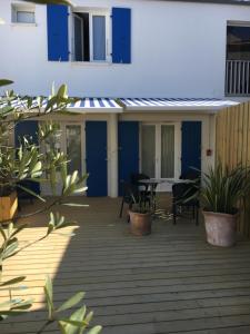 um pátio com cadeiras e uma mesa num edifício em Les Bains Boyardville - Hôtel et Restaurant em Boyard-Ville