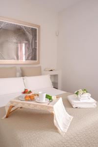 a bed with a tray of fruit on a table at U-Sense Sevilla Santa Cruz in Seville