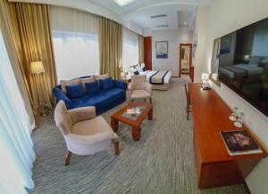 a large living room with a blue couch and chairs at Hotel Montenegrino in Tivat