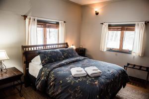 a bedroom with a bed with two towels on it at Brook Road Cabin in Goshen