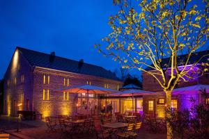 a building with tables and umbrellas at night at Zum Rittmeister in Werder