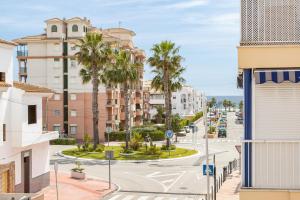 une rue de la ville avec des palmiers et des bâtiments dans l'établissement Apartamento Flamingo, à Torrox Costa