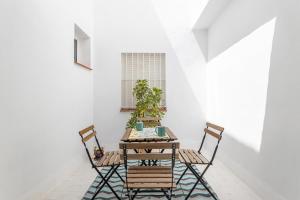 a table and chairs in a room with white walls at Apartamento Pintada 25 in Nerja
