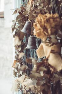 un groupe de cloches sur un mur avec une plante dans l'établissement La Villa Celestine, à Chablis