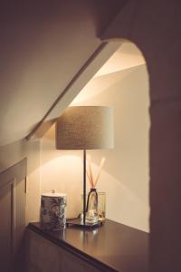 een lamp op een tafel in een kamer bij La Villa Celestine in Chablis